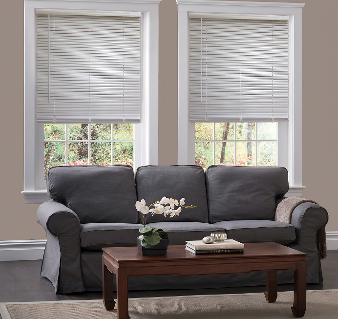 Modern living room with grey sofa, wooden coffee table, and white window blinds